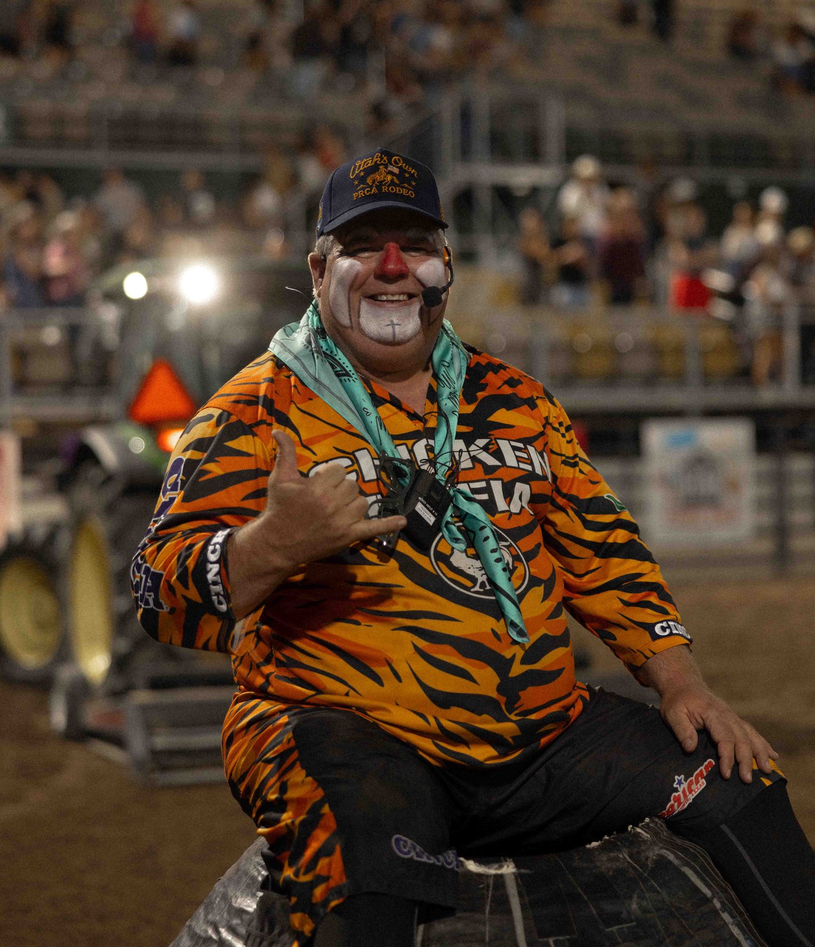 Rodeo clown in a custom tiger-stripe Loud Face shirt and Utah's Own PRCA Rodeo hat giving a shaka sign