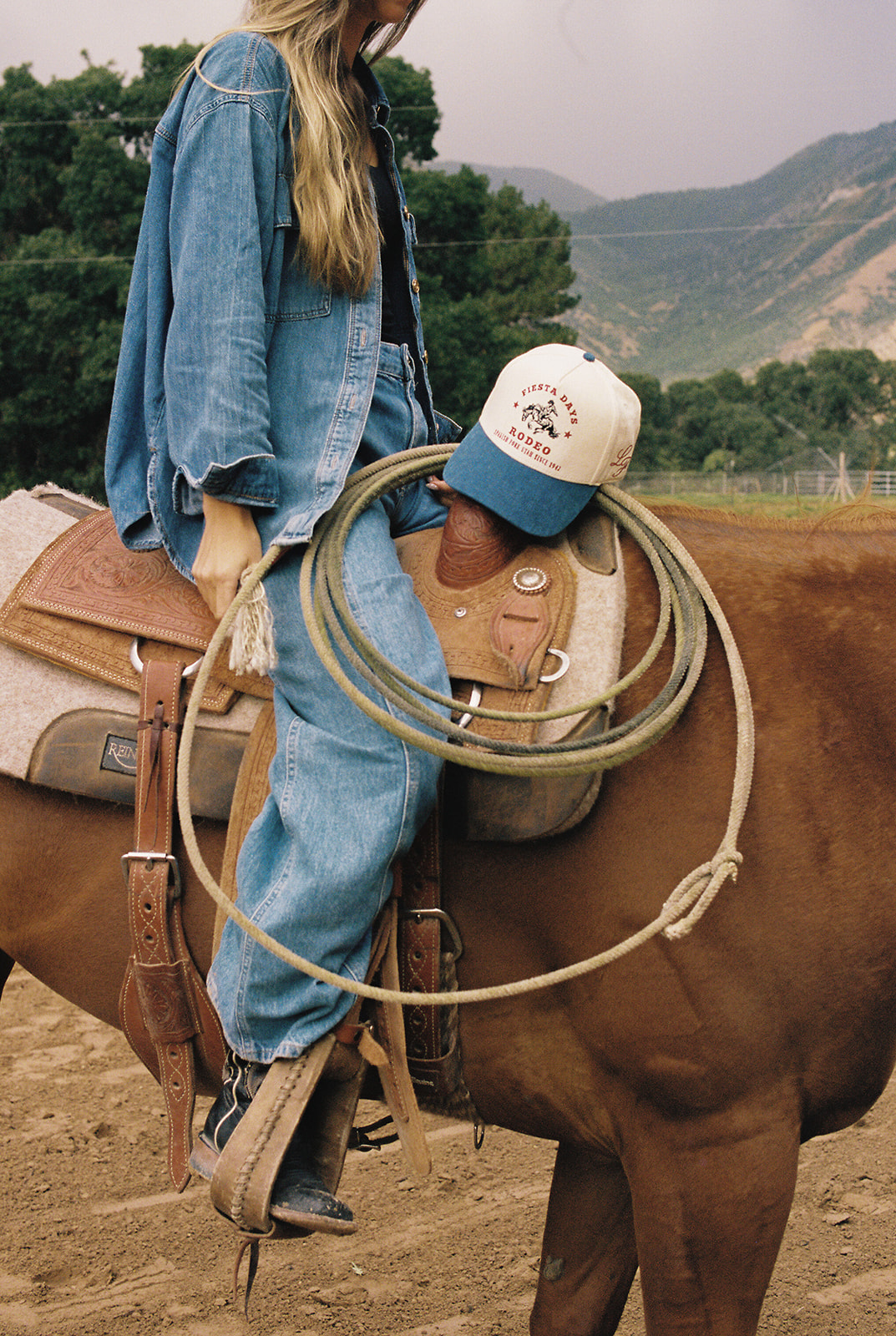 Rider on horseback with custom rodeo cap and rope